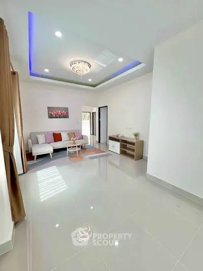 Spacious modern living room with elegant ceiling lights and cozy seating area.