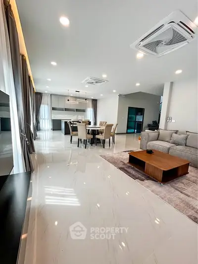 Spacious modern living room with open layout and elegant dining area, perfect for entertaining.