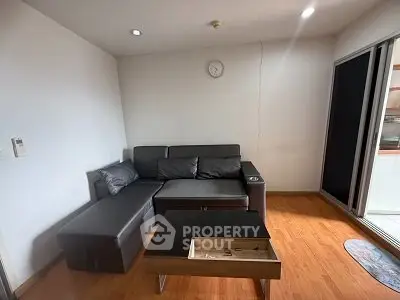 Cozy living room with modern furniture and wooden flooring, perfect for relaxation.