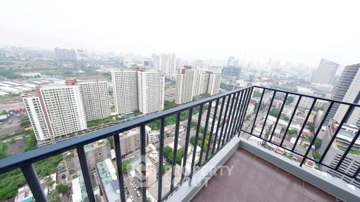 Stunning cityscape view from high-rise balcony with modern railing design.