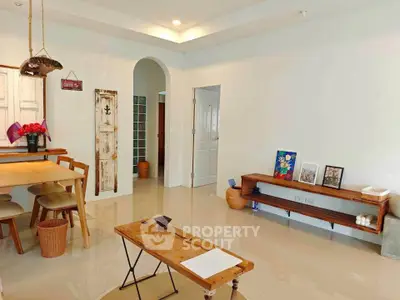 Charming living room with rustic decor and natural light, featuring a cozy dining area and unique wooden furniture.