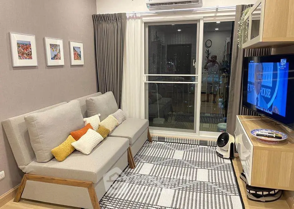 Modern living room with stylish decor, cozy seating, and balcony access in a contemporary apartment.