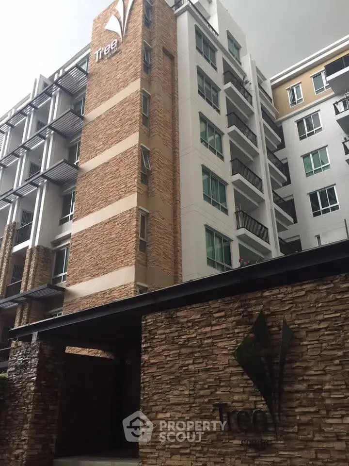 Modern apartment building with stone facade and sleek design in urban setting.