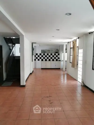 Spacious open-plan living area with tiled flooring and modern kitchen