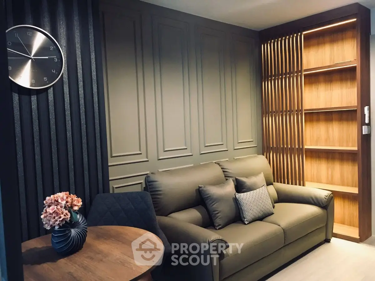 Stylish living room with modern decor, featuring a cozy sofa, elegant wall paneling, and a chic wooden bookshelf.