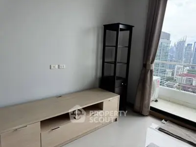 Modern living room with city view and balcony access, featuring sleek furniture and large windows.