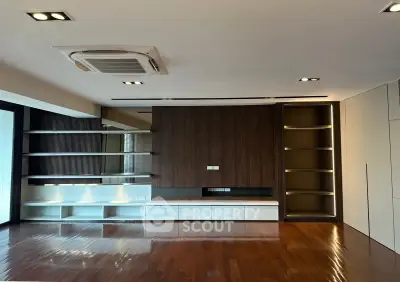 Spacious modern living room with wooden flooring and built-in shelves