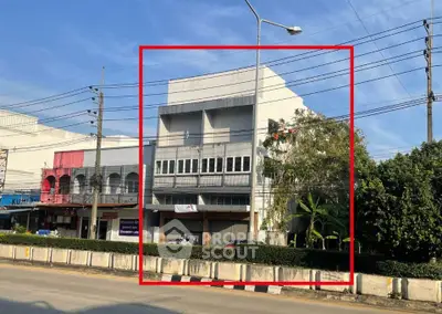 Commercial building for sale on busy street with potential for retail or office space.