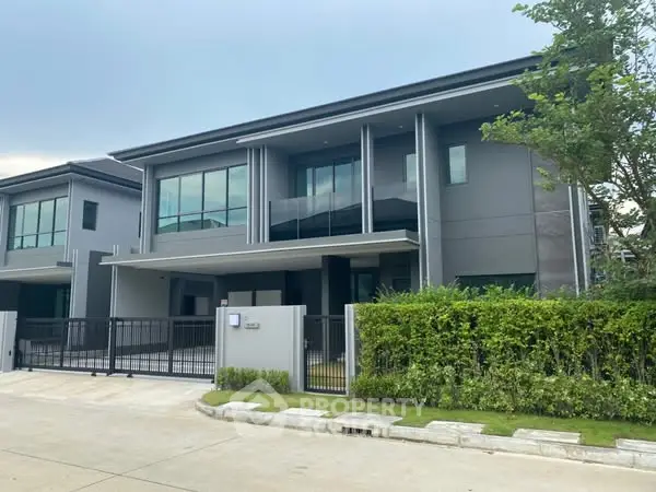 Modern two-story house with sleek design and spacious driveway in a serene neighborhood.