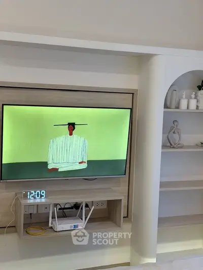 Modern living room with built-in TV and stylish shelving unit, showcasing contemporary design.