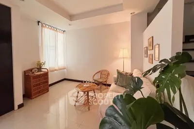Cozy living room with natural light, rattan furniture, and elegant decor.