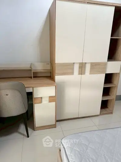 Modern bedroom with sleek wardrobe, study desk, and comfortable chair, perfect for stylish living.