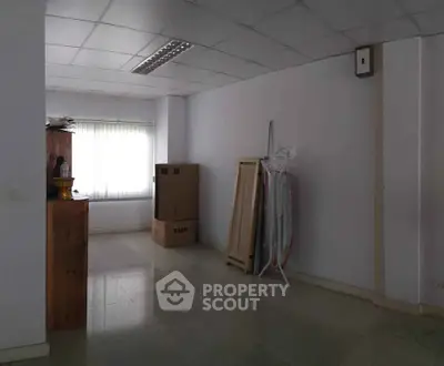 Spacious unfurnished room with large window and tiled floor, ideal for customization.