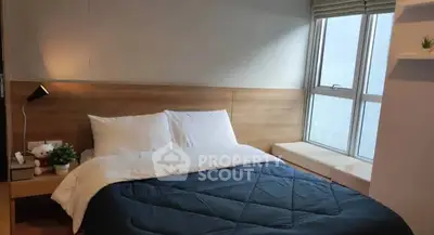 Cozy bedroom with large window and modern decor, perfect for relaxation and comfort.