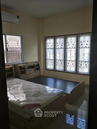 Spacious bedroom with large windows and modern bed frame