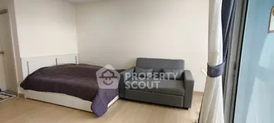 Cozy bedroom with a stylish gray sofa and modern decor