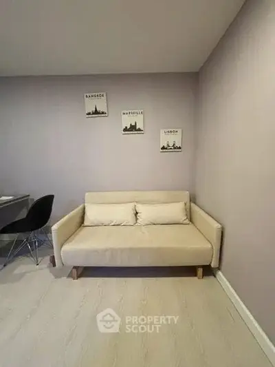 Cozy living room with beige sofa and cityscape wall art, perfect for modern urban living.