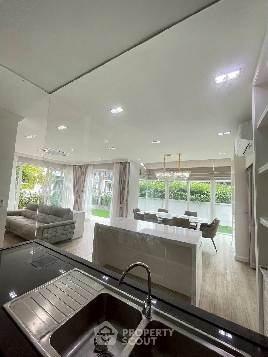 Luxurious open-plan living room with modern kitchen and garden view