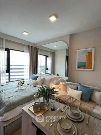 Chic modern bedroom with dining area, featuring cozy decor and large windows for natural light.