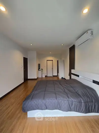 Spacious bedroom with modern design and wooden flooring