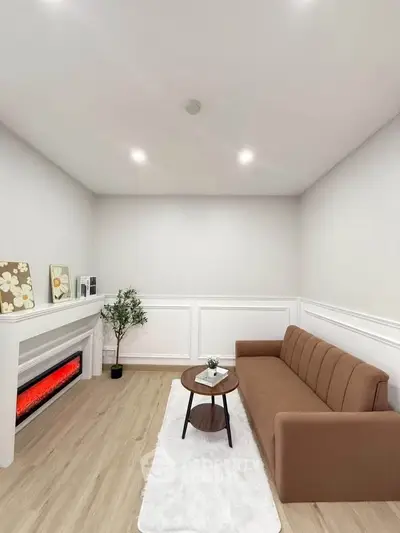 Modern living room with sleek brown sofa, elegant fireplace, and minimalist decor.
