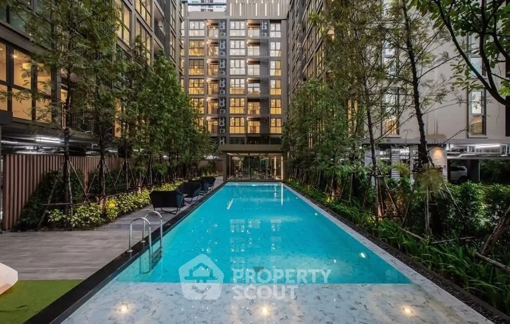 Luxurious apartment complex with a stunning outdoor pool and lush greenery.