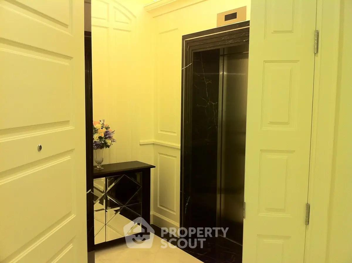 Elegant building entrance with mirrored console and modern elevator