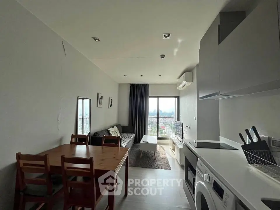Modern living room with dining area and kitchen in open layout, featuring city view.