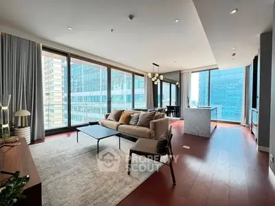 Luxurious modern living room with floor-to-ceiling windows and open kitchen in high-rise apartment.