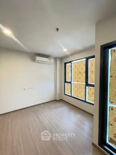 Bright empty room with large windows and air conditioning, perfect for customization.