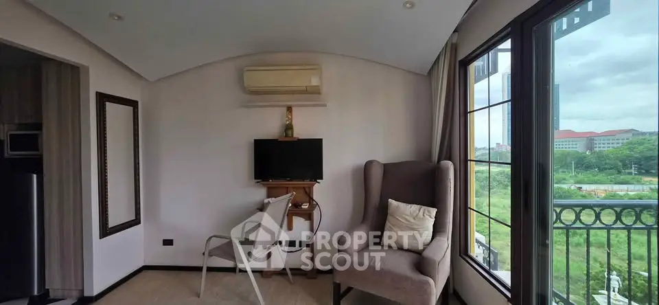 Cozy living room with large windows and scenic view, featuring modern furniture and air conditioning.