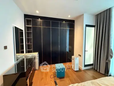 Modern bedroom with sleek black wardrobe and hardwood floors