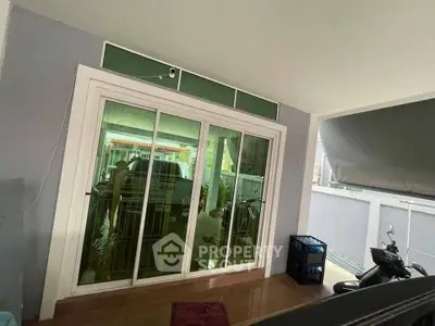 Modern home entrance with sliding glass doors and covered patio area.