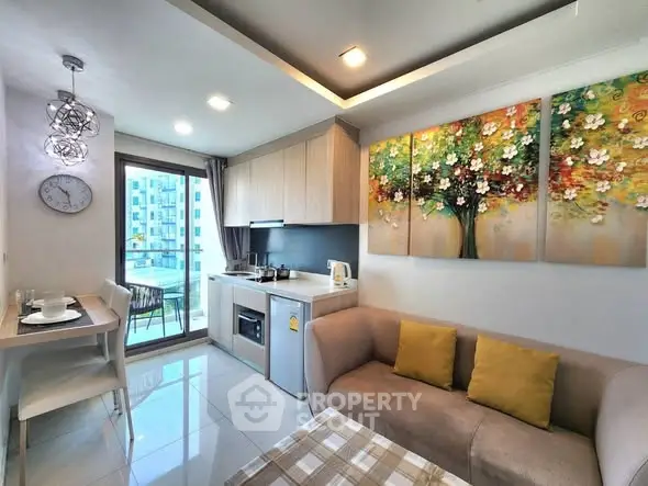 Modern living room with open kitchen and balcony view in stylish apartment.