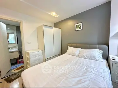 Cozy bedroom with modern decor and ensuite bathroom in a stylish apartment.