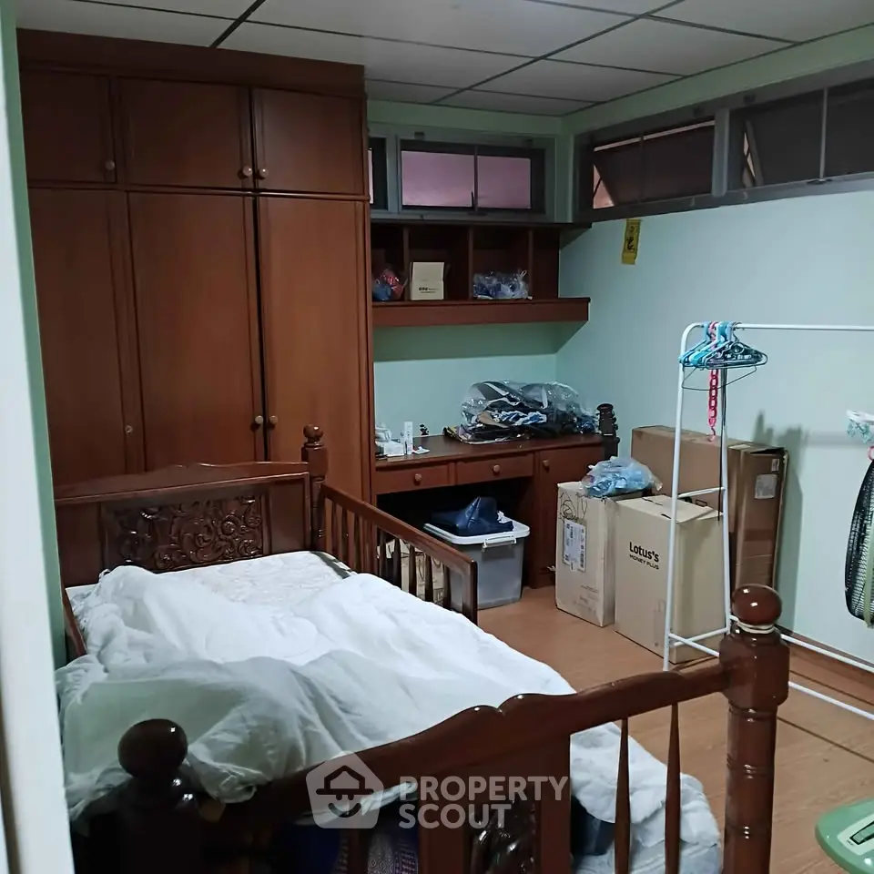 Cozy bedroom with wooden furniture and ample storage space, perfect for a comfortable living experience.