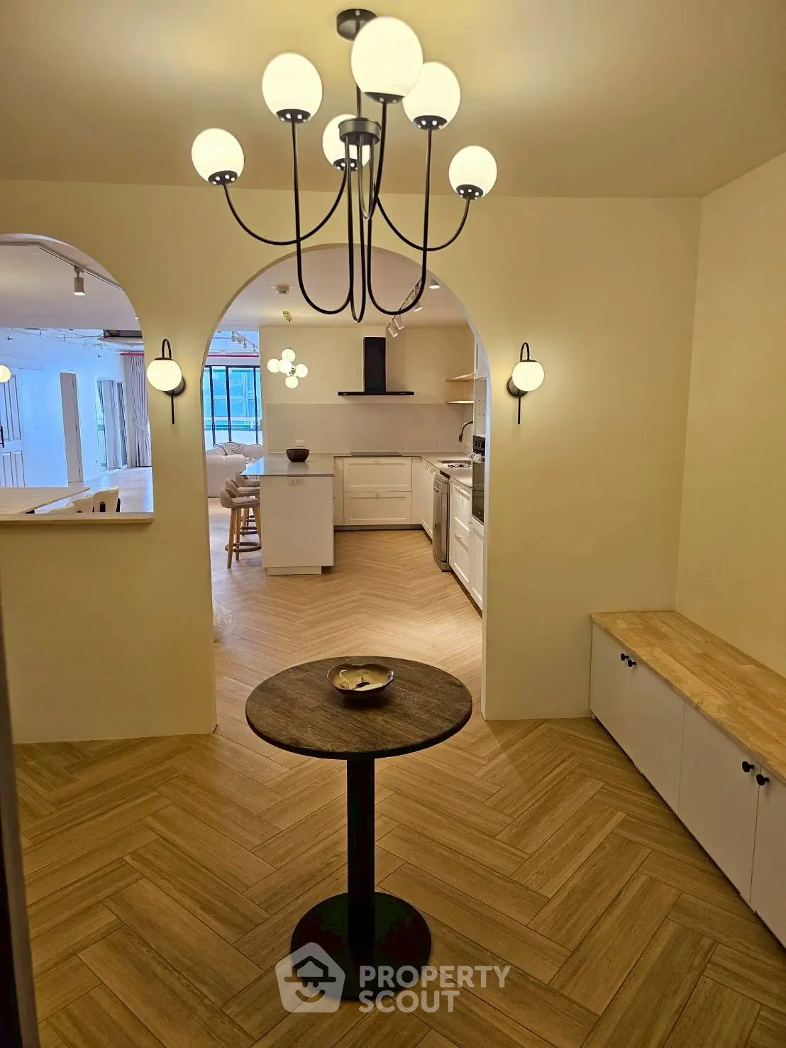 Charming open-layout kitchen with elegant lighting and cozy dining area.