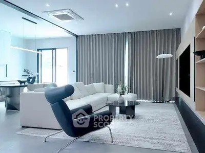 Modern living room with sleek furniture and large windows for natural light.