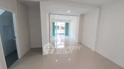 Spacious open-plan living area with glossy floors and ample natural light