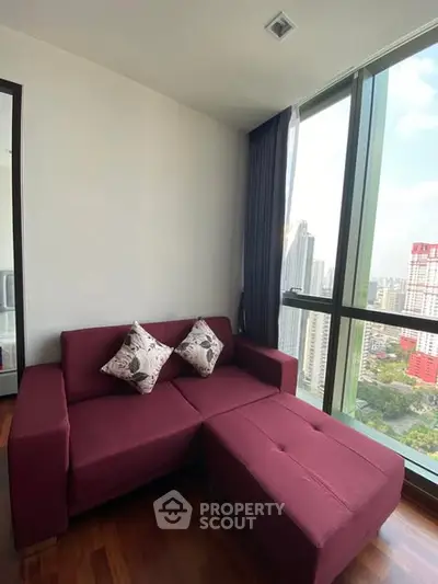 Cozy living room with red sofa and stunning city view from large window