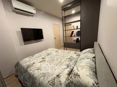 Cozy bedroom with modern decor and wall-mounted TV, perfect for relaxation.