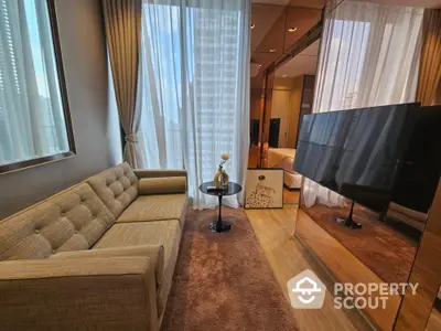 Luxurious modern living room with plush sofa and large TV, perfect for relaxation and entertainment.