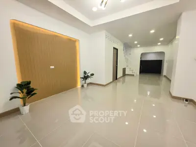 Spacious modern living room with glossy tiled floors and elegant lighting