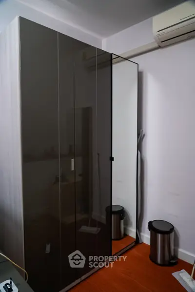 Modern bedroom with sleek wardrobe and air conditioning unit, perfect for urban living.