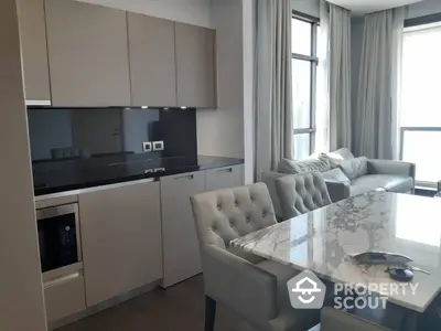 Elegant modern kitchen with integrated appliances and a marble dining table, complemented by plush seating and natural light.