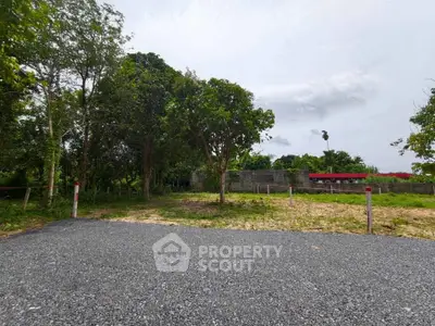 Spacious vacant land plot with lush greenery and potential for development.