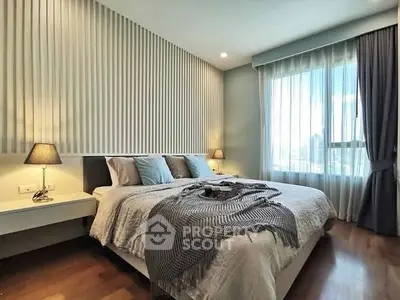 Luxurious bedroom with elegant decor and large window offering city views.