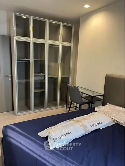 Modern bedroom with glass wardrobe and study desk, perfect for urban living.