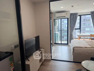 Modern apartment interior with bedroom and living area, featuring large windows and balcony access.