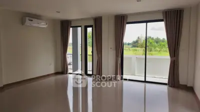 Spacious living room with large windows and balcony view